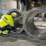 Arbetare inspekterar stora rör vid Slite cementfabrik.
