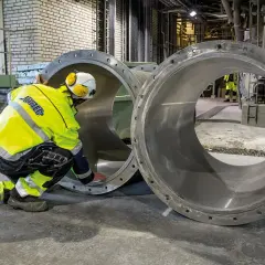 Arbetare inspekterar stora rör vid Slite cementfabrik.