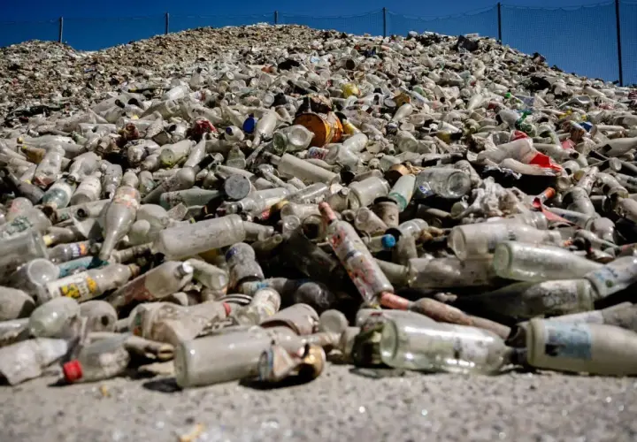 Enorm hög med glasflaskor och burkar, redo för glass recycling. En påminnelse om vikten av återvinning.