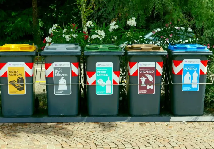 Fem sopsorteringskärl för återvinning, inklusive plast och papper. Inga kärl för farligt avfall syns.