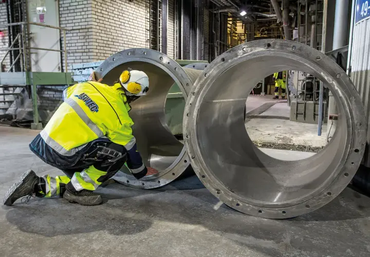 Arbetare inspekterar stora rör vid Slite cementfabrik.