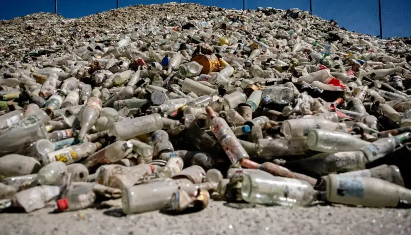 Enorm hög med glasflaskor och burkar, redo för glass recycling. En påminnelse om vikten av återvinning.
