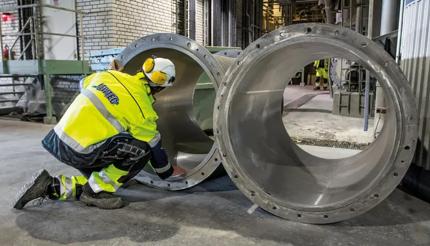 Arbetare inspekterar stora rör vid Slite cementfabrik.