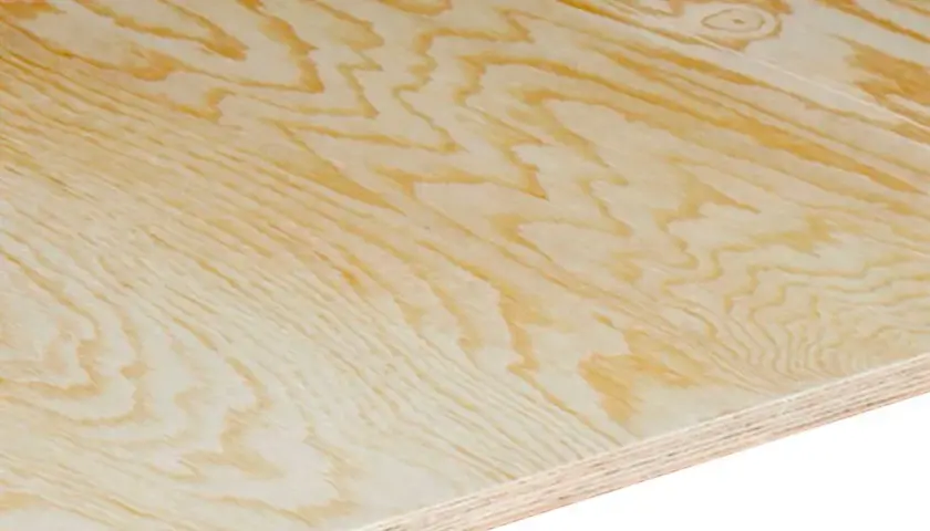 Närbild på en skiva plywood utomhus med tydliga ådringar och lager. Perfekt för byggprojekt i trädgården.