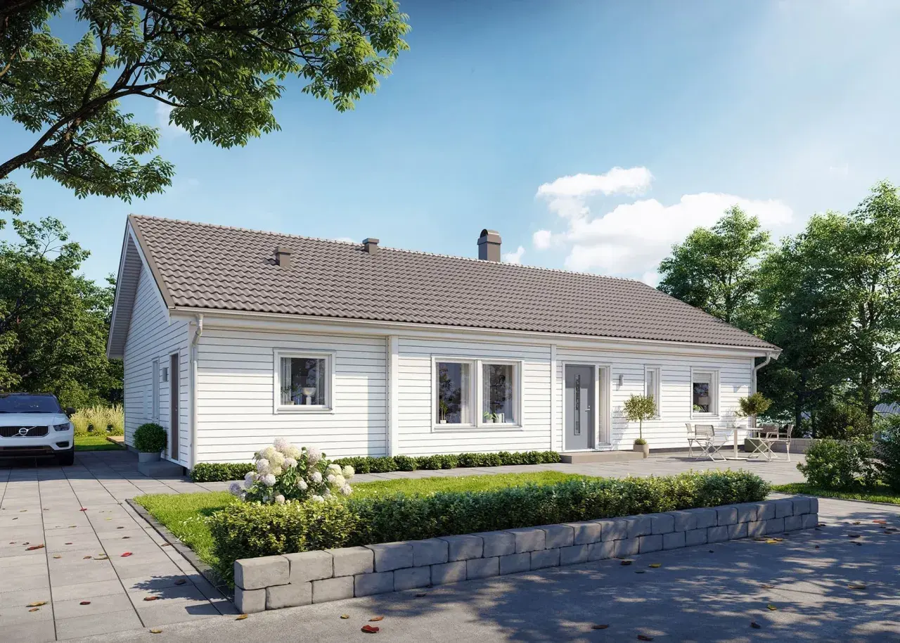 Vitt, modernt betong hus med grå takpannor, omgivet av grönska och träd. En vit bil parkerad på uppfarten.