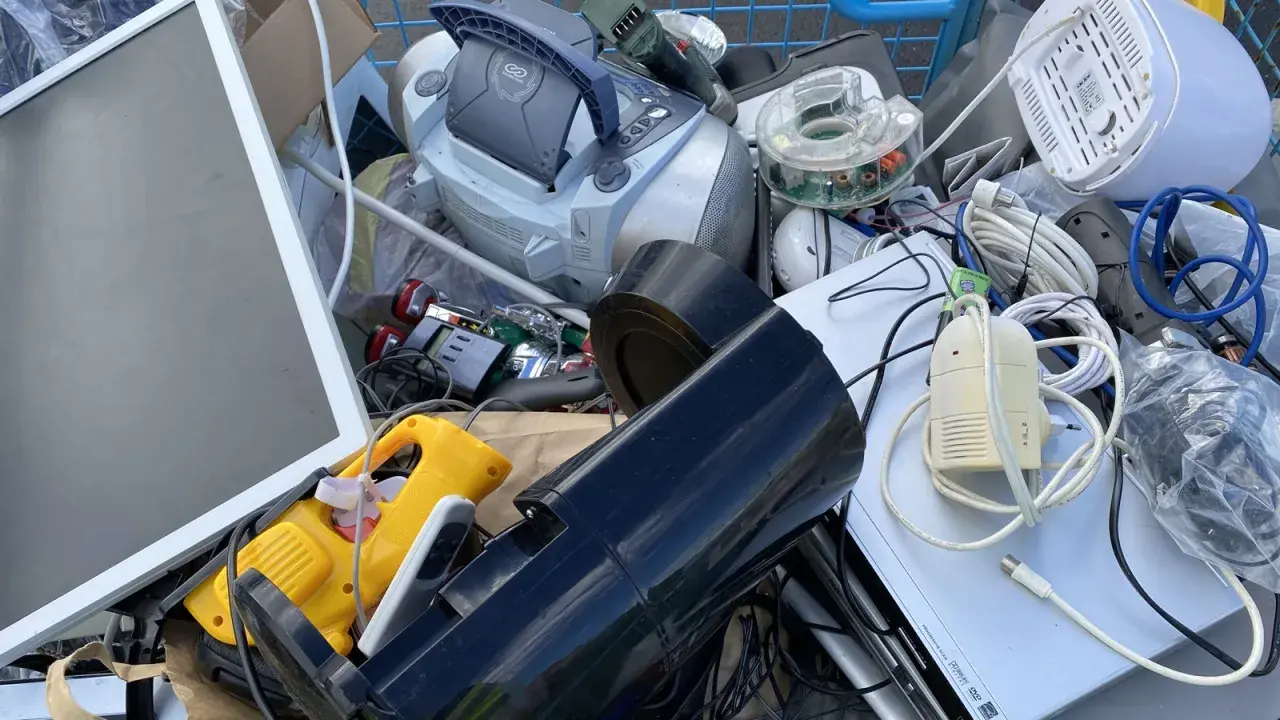 En vagn fylld med elektronik för återvinning av elektronik. En skärm, en stereo, sladdar och andra prylar.
